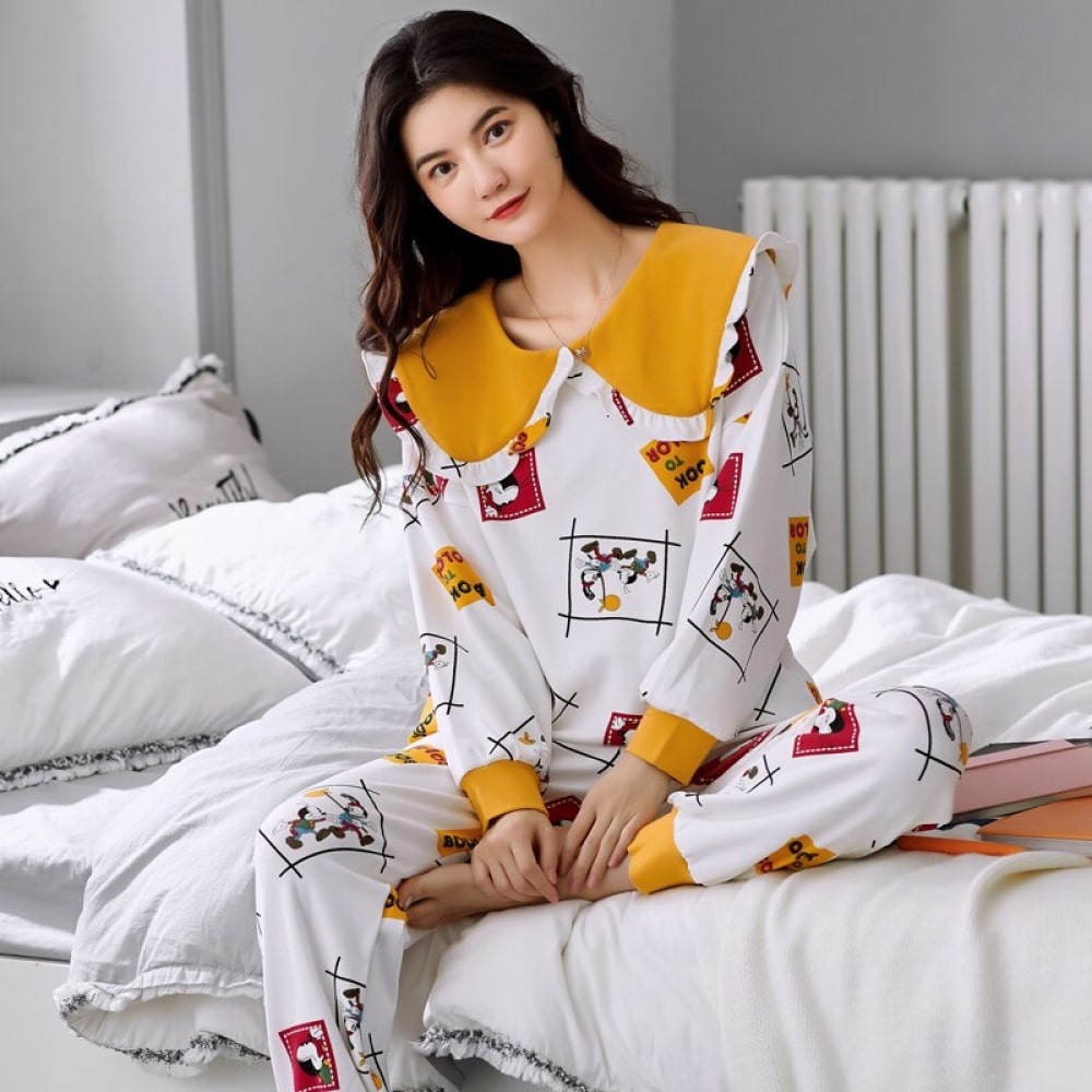 Hoogwaardige katoenen pyjama met lange mouwen voor vrouwen, gedragen door een vrouw zittend op een bed in een huis