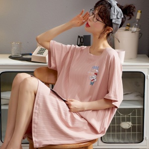 Katoenen zomerpyjama met korte mouwen voor vrouwen, gedragen door een vrouw zittend op een stoel in een huis