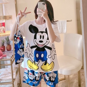 Mickey Mouse bedrukte satijnen zomerpyjamaset gedragen door een vrouw in een huis