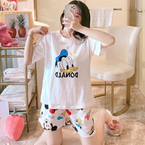 Witte satijnen zomerpyjama met Donald-opdruk, gedragen door een vrouw in een huis