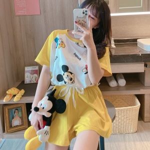 Gele Mickey Donald print zomerpyjama gedragen door een vrouw met pluche knuffel
