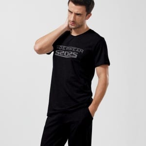 Modieuze herenpyjama in zwart katoen, gedragen door een modieuze man