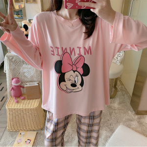 Katoenen pyjama met lange mouwen met Minnie Mouse opdruk en een meisje dat de pyjama draagt en een slaapkamerachtergrond