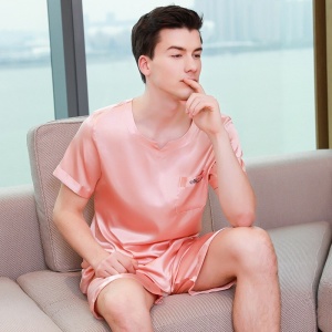 Roze satijnen pyjama voor mannen. Het is een pyjamaset met een korte broek en een satijnen t-shirt