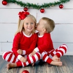 Kerstpyjama met strepen voor een klein meisje en een kleine jongen in stijl