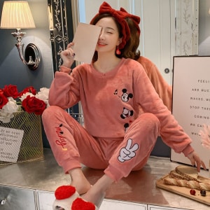 Roze Mickey-pyjama voor vrouwen gedragen door een vrouw met een rode hoofdband in een modieus huis