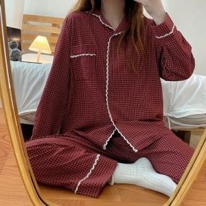 Een retro geruite winterpyjama voor vrouwen, gedragen door een vrouw die een foto neemt voor een spiegel