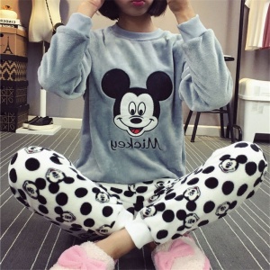 Tweedelige pyjama met Mickey-kop, de bovenkant is een grijze trui met Mickey-kop en de onderkant is een broek met zwarte Mickey-kop, gedragen door een jonge vrouw
