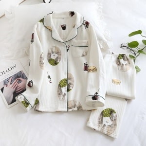 Witte katoenen pyjama met lange mouwen en konijnenprint voor wintermode met een bloemenblad op de zijkant en een tijdschrift