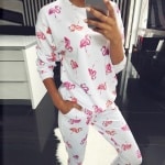 Warme pyjama met exotisch wit en roze patroon met een vrouw die de pyjama draagt
