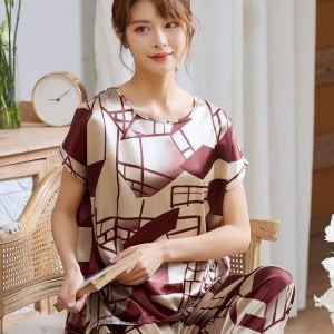Luxe tweedelige pyjama met korte mouwen voor vrouwen, gedragen door een vrouw zittend op een stoel in een huis