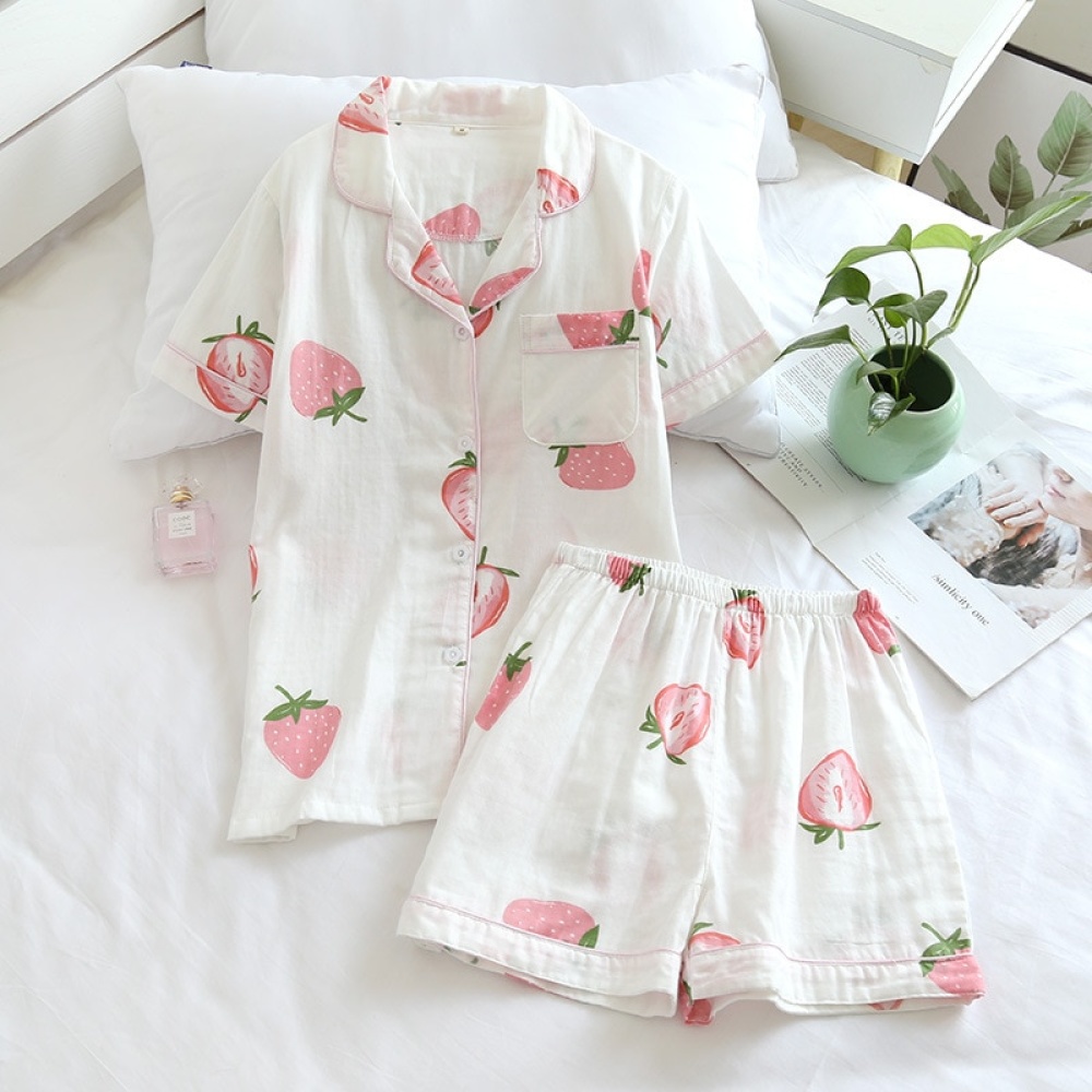 Zomerpyjama met korte mouwen en aardbeienprint voor vrouwen op een bed met een kleine vaas en een bloem erin in een huis