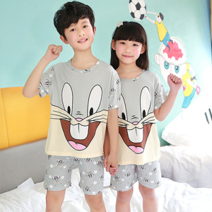 Grijze zomerpyjama met korte mouwen en Bugs Bunny patroon voor kinderen gedragen door kinderen in een huis