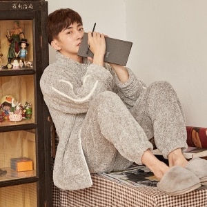 Warme pyjamaset voor heren in grijs met een man die de pyjama draagt