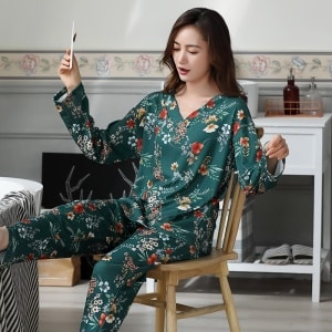 Tweedelige damespyjama met V-hals en bloemenmotief en een slaapkamerachtergrond