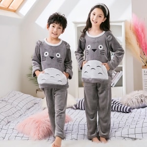 Grijze fleece pyjama met Toroto print voor een kind gedragen door een kleine jongen en een klein meisje met een hoofdband op een bed in een huis