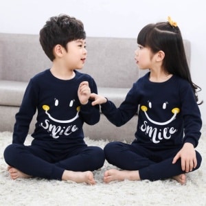 Tweedelige voorjaarspyjama met glimlachmotief voor kinderen donkerblauw met twee kinderen die de pyjama dragen