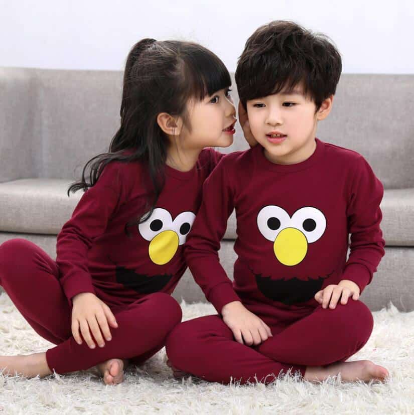Lente tweedelige kinderpyjama met twee kinderen die de pyjama dragen en een bank op de achtergrond