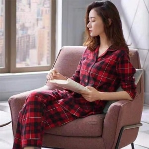Tweedelige voorjaarspyjama met ruitjesprint voor vrouwen gedragen door een vrouw zittend op een stoel in een huis