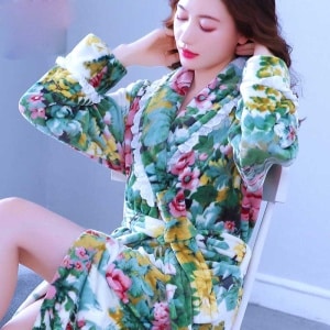 Koraalkleurige fleece pyjama met kant en bloemmotief gedragen door een zeer modieuze vrouw