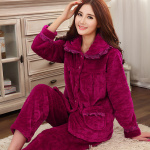 Modieuze damespyjama in effen kleur, gedragen door een vrouw zittend op een tapijt in een huis